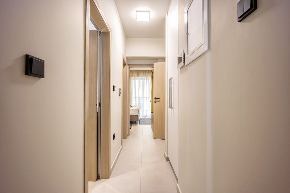 Bright corridor leads to inviting retreat, where soft light and tasteful design create calming everyday comfort