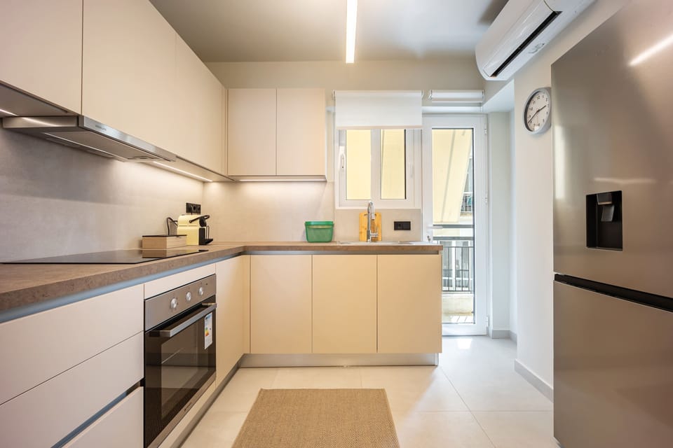 Bright kitchen with sleek design, full amenities, and balcony access for effortless Athens dining experience