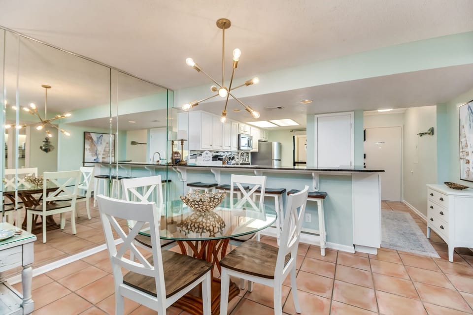 Open-concept dining with comfortable seating for 4 and stunning Old River views at Wind Drift Orange Beach bayfront condo