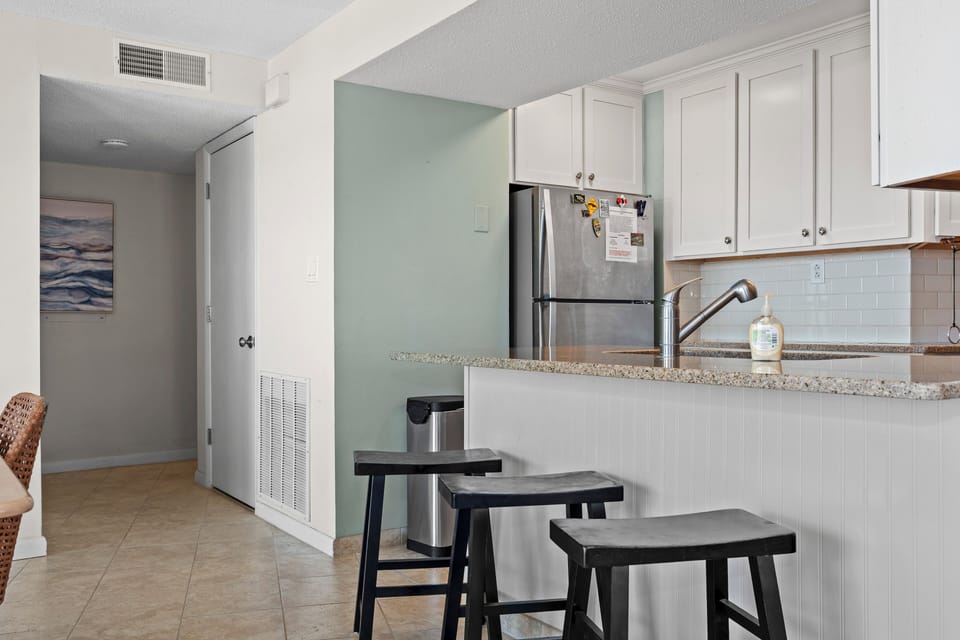 Your fully equipped kitchen features granite countertops, stainless steel appliances, and bar seating perfect for morning coffee or casual meals.