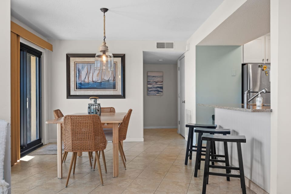 Gather around your elegant dining table under nautical-inspired lighting, where ocean artwork sets the mood for memorable meals.
