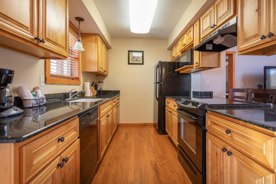 Whip up delicious meals in this fully equipped kitchen, featuring beautiful cabinetry and ample counter space, ready for family feasts and culinary adventures.