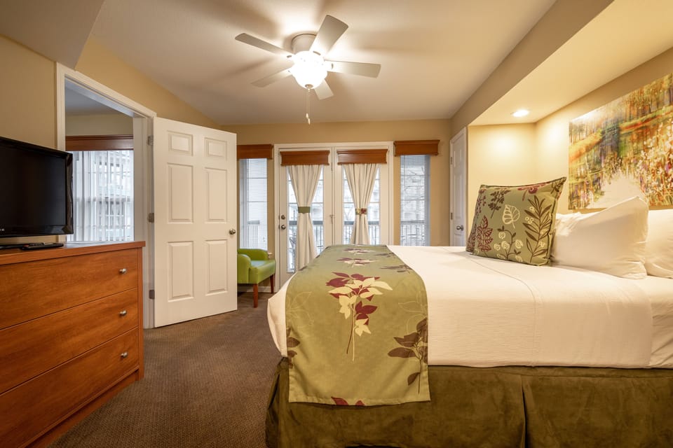 Bright room featuring a king bed and balcony.