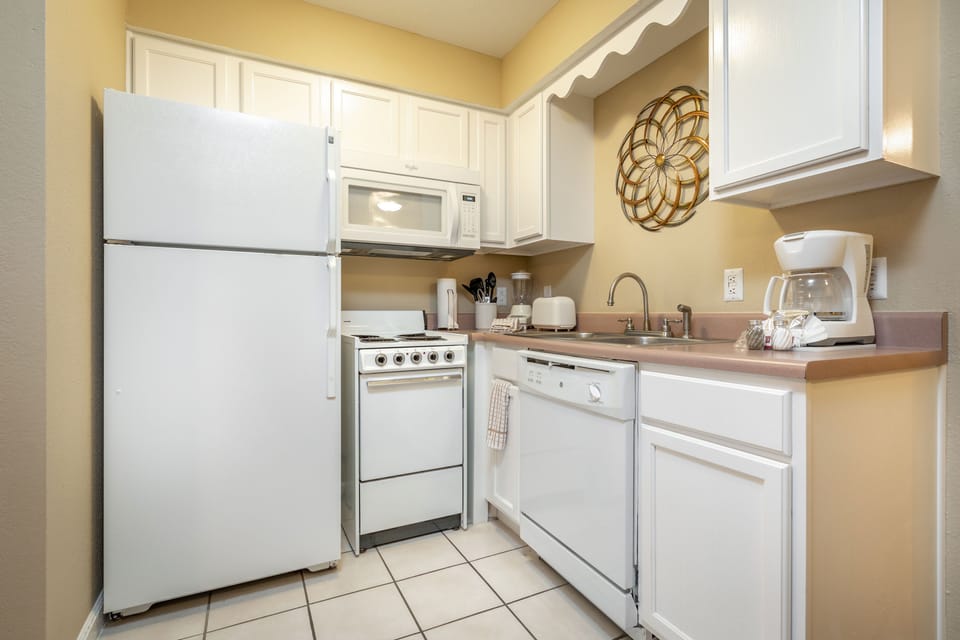 Fully equipped kitchen with stove, oven, dishwasher, full-size fridge, microwave, and coffee maker