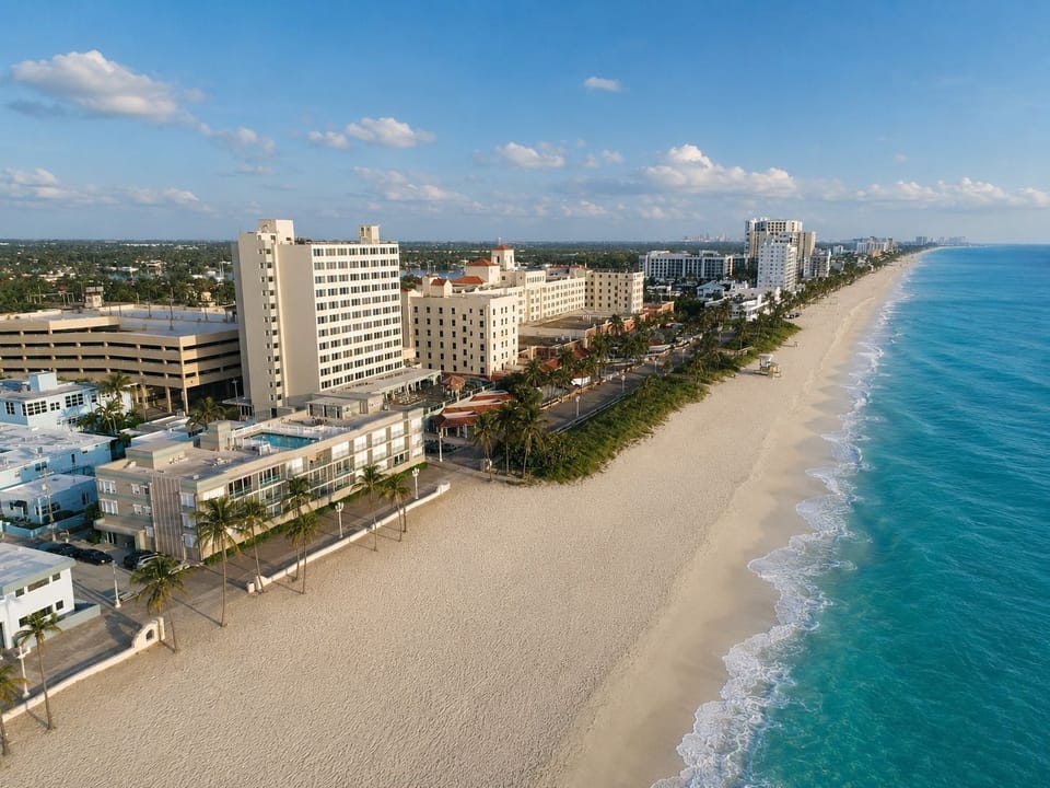 Beachfront with hotels and palm trees under a blue sky