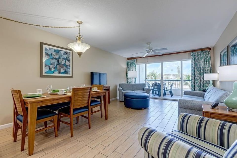 Enjoy delightful family meals in the spacious living and dining area, featuring a comfortable sofa and direct access to a private balcony that showcases stunning ocean views.