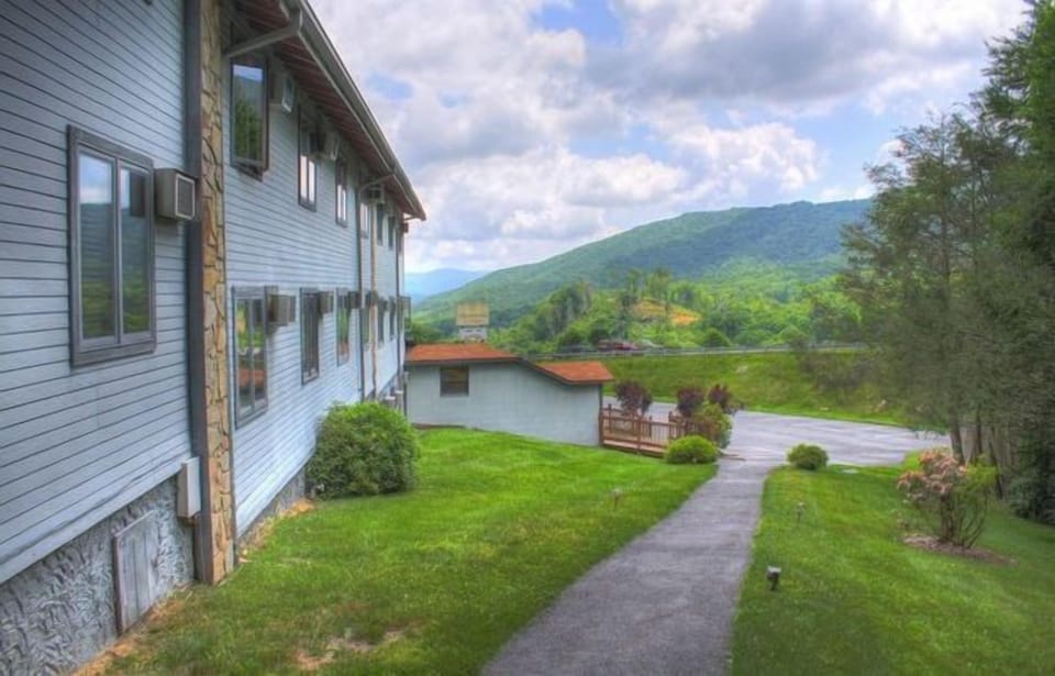 This charming studio features a queen bed and a partial kitchenette, set against a stunning mountain backdrop, just moments away from ski resorts.