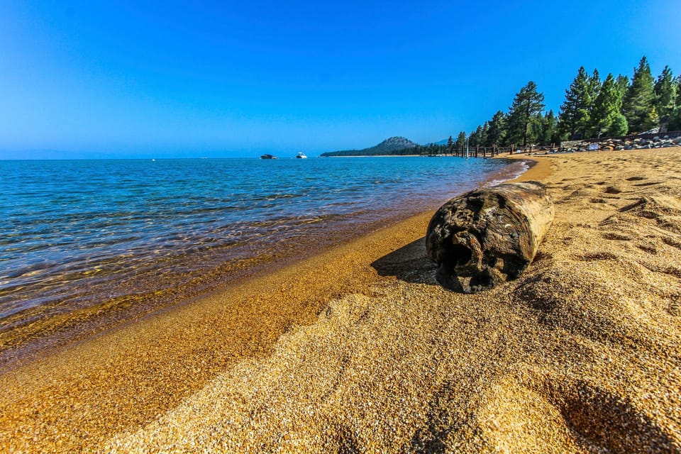 Sandy beach with clear lake and distant hills