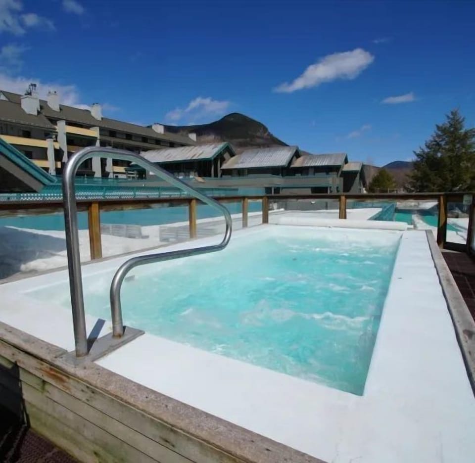 Relax in the inviting hot tub, offering a serene experience against the backdrop of the beautiful mountain landscape.