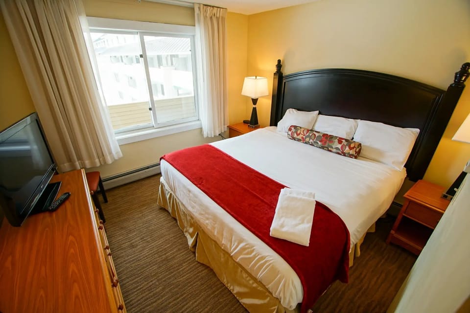 Retreat to a beautifully appointed master bedroom, complete with a plush king bed and modern amenities, ensuring a restful night in the heart of nature's beauty at Loon Mountain.