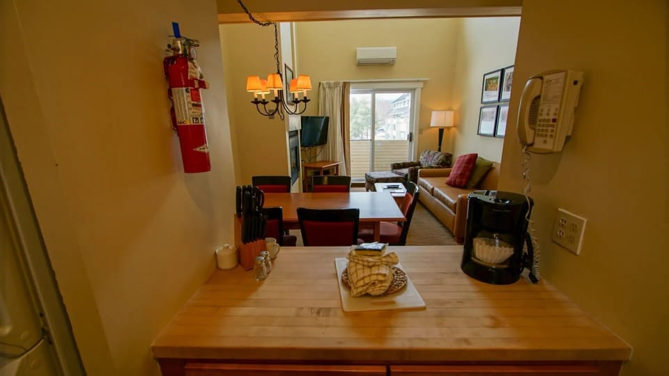 Experience the warm and inviting atmosphere of this 2-bedroom loft cabin, featuring a full kitchen and dining area that seamlessly connects to the cozy living space, perfect for relaxing after a day of adventure.