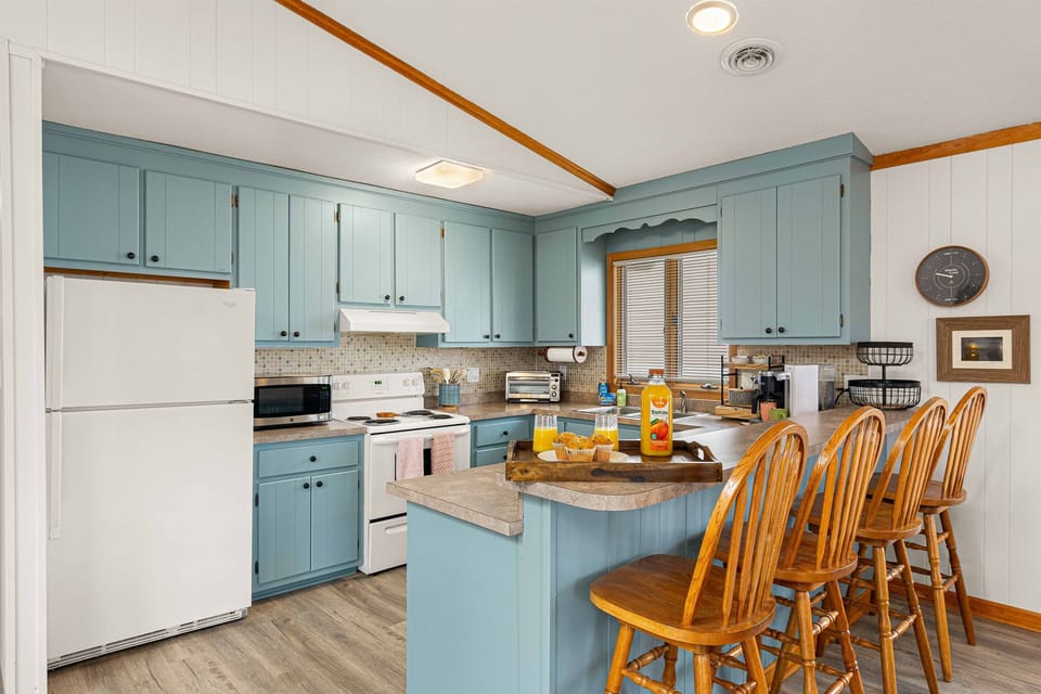 Charming cabinetry adds a warm and inviting touch to this well-equipped kitchen.   Additional bar seating provides a casual space for snacks or chatting while cooking.
