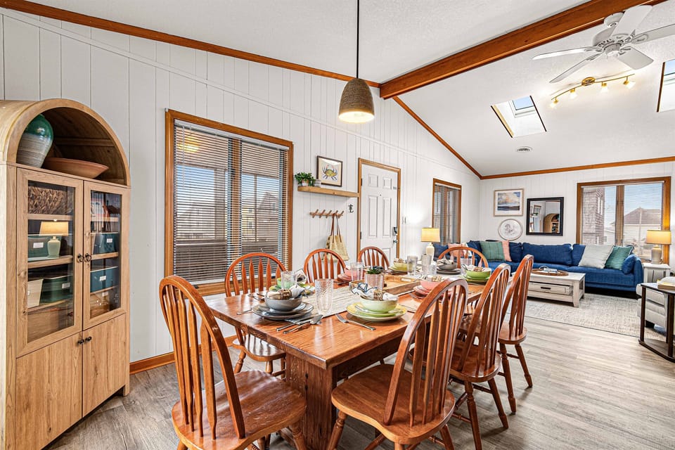 The large dining table comfortably seats eight, perfect for shared meals or family game nights.