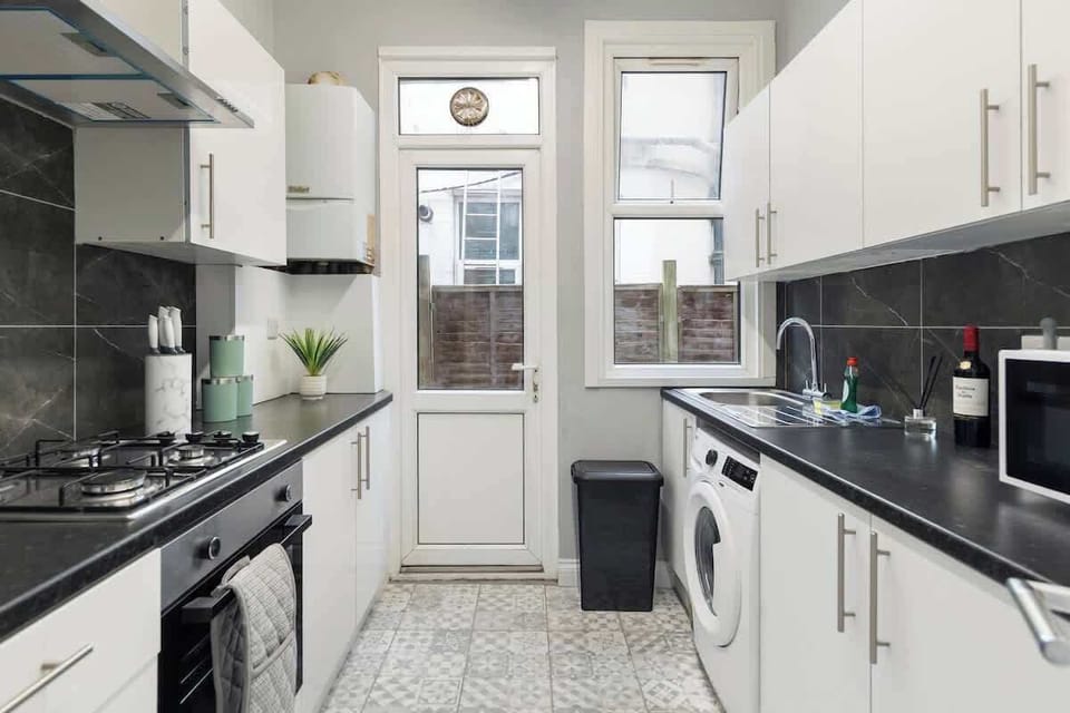 - Cook with ease in a fully equipped kitchen featuring modern design  
- Appliances include stove, microwave, washer, and essentials  
- Convenient layout with direct access to the outdoor space  