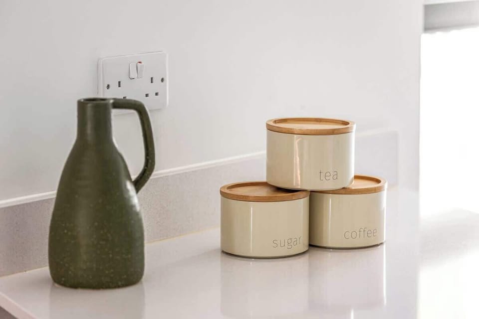 - Kitchen detail with stylish jars and a decorative pitcher set  
- Functional storage blends with minimalist Airbnb design  
- Aesthetic accents that enhance the cooking space experience  