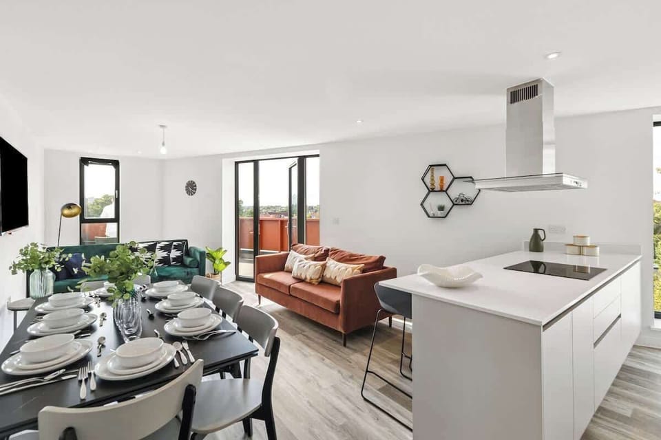 - Open plan living room and kitchen designed for social gatherings  
- Large dining table set for meals and conversations with your group  
- Modern décor with bright seating and natural light throughout the space  
