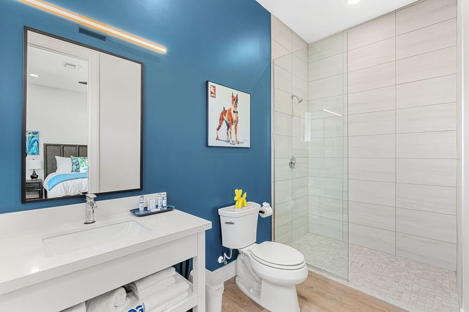 Sparkling bath with fresh towels, sleek shower & a backlit mirror.
