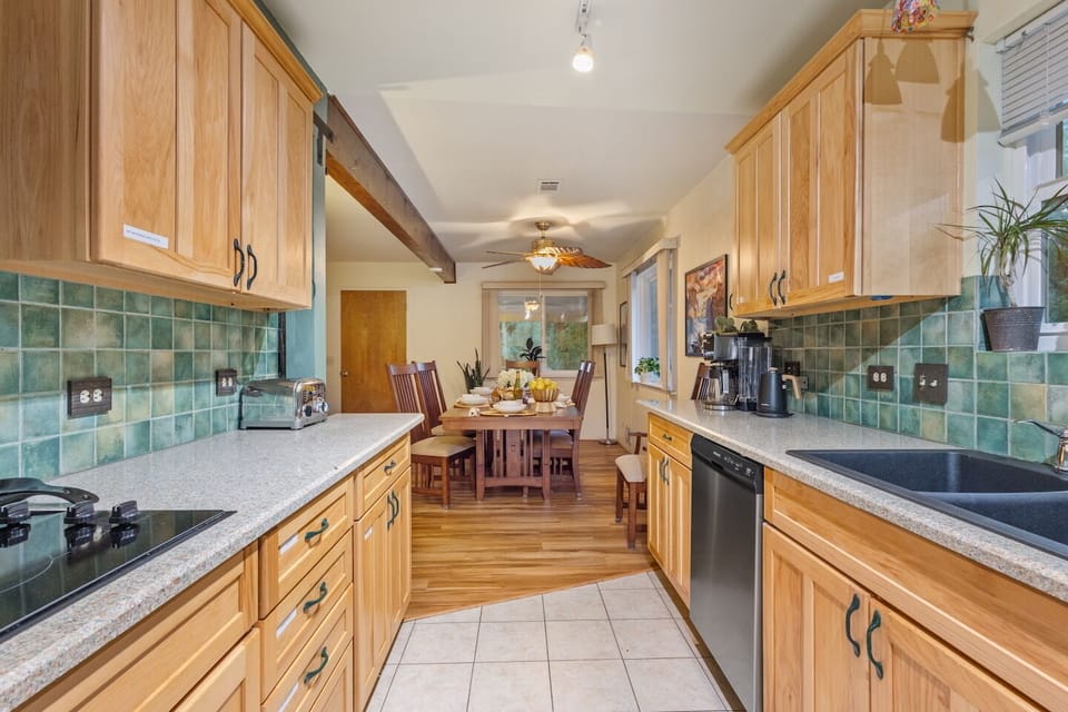 Bright kitchen with granite countertops, modern appliances, and an open flow into the dinning area. 