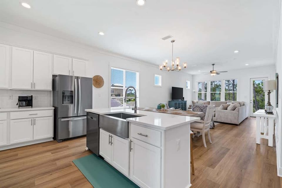 Open concept hosts 13 comfortably: Kitchen, dining room, living room with access to back patio overlooking nature views and canal. Family vacation central!