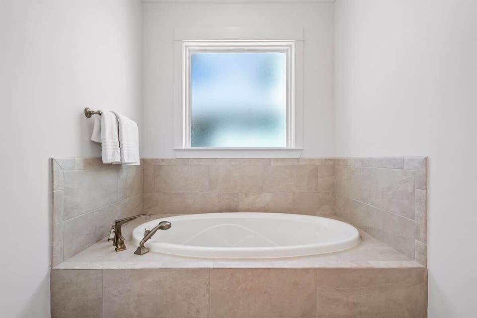 Master bathroom: Deep soaking tub with natural light.