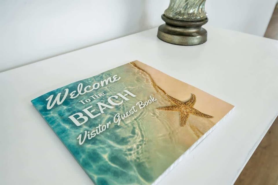 Welcome table-entryway - beautiful coastal decor with bench seating in the entryway. Natural lighting from the front door and open concept kitchen/dining room.