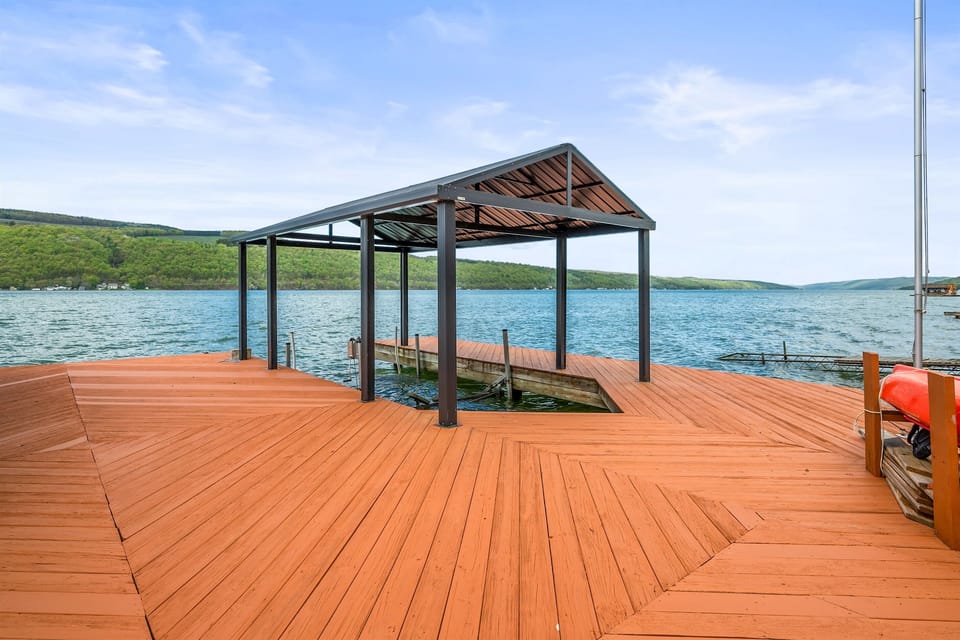 Expansive lakefront deck with seating, a canoe, and stunning water views—your private Finger Lakes retreat. 🚣‍♀️🌊☀️