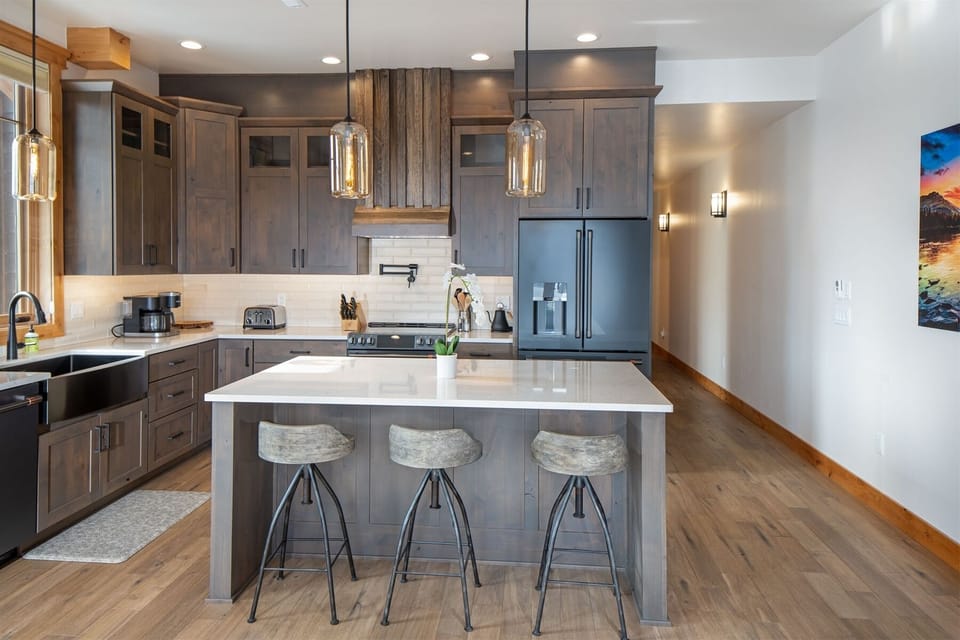 The kitchen features modern fixtures, high end appliances & island with seating | Main Level