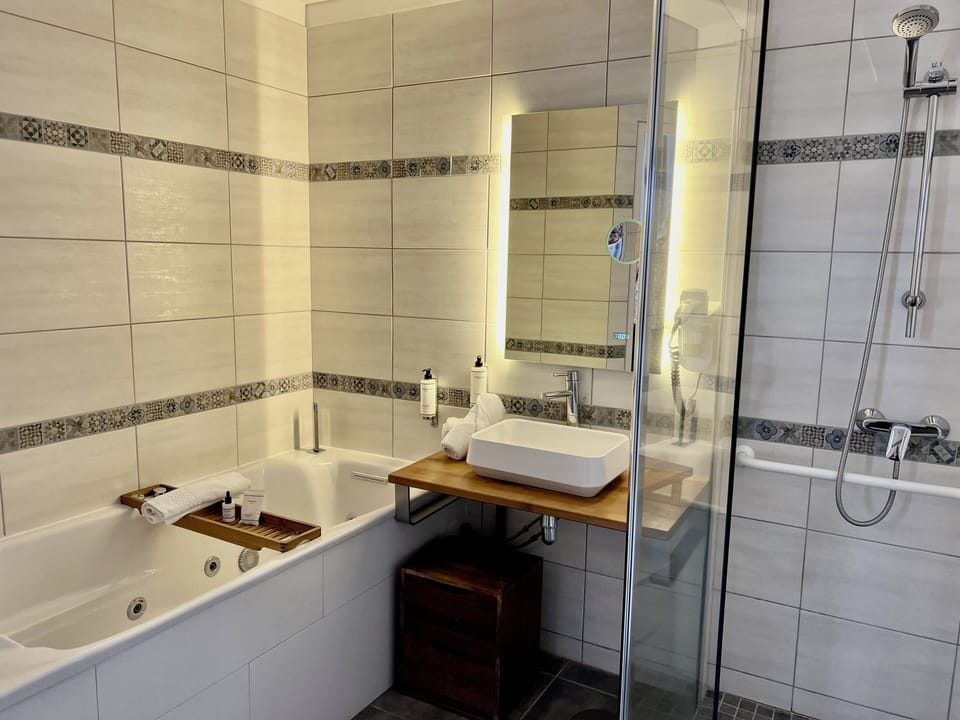 Deluxe Room | Bathroom | Hair dryer, towels, soap, shampoo