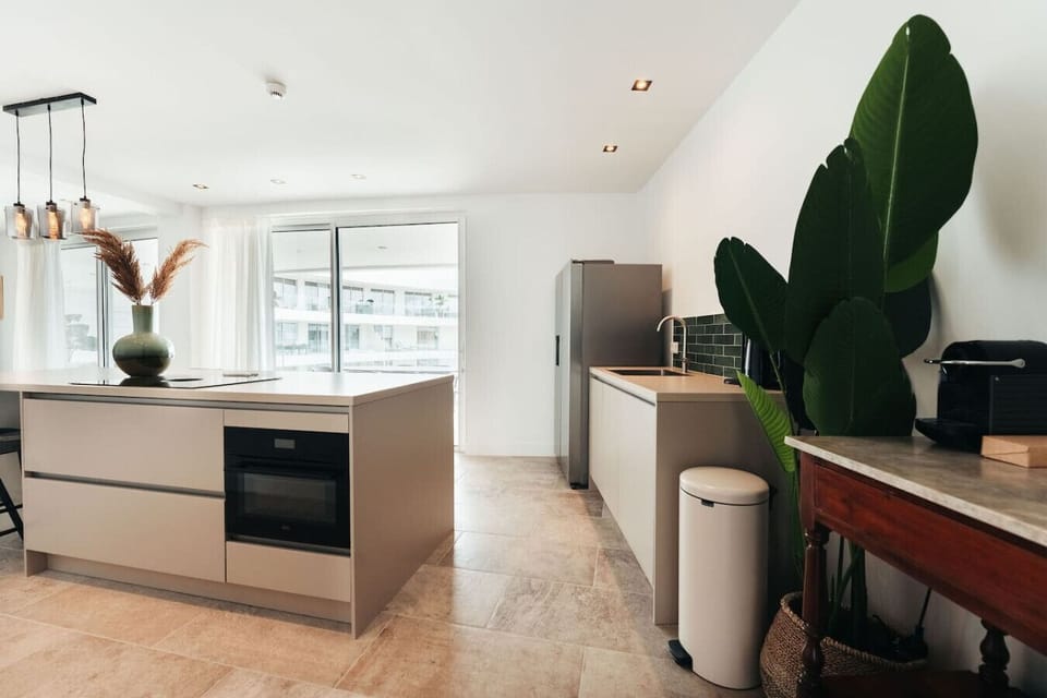 Prepare a delicious feast in this modern, open-concept kitchen featuring a spacious island, premium finishes, and plenty of room to gather before heading out to the sun-soaked terrace.