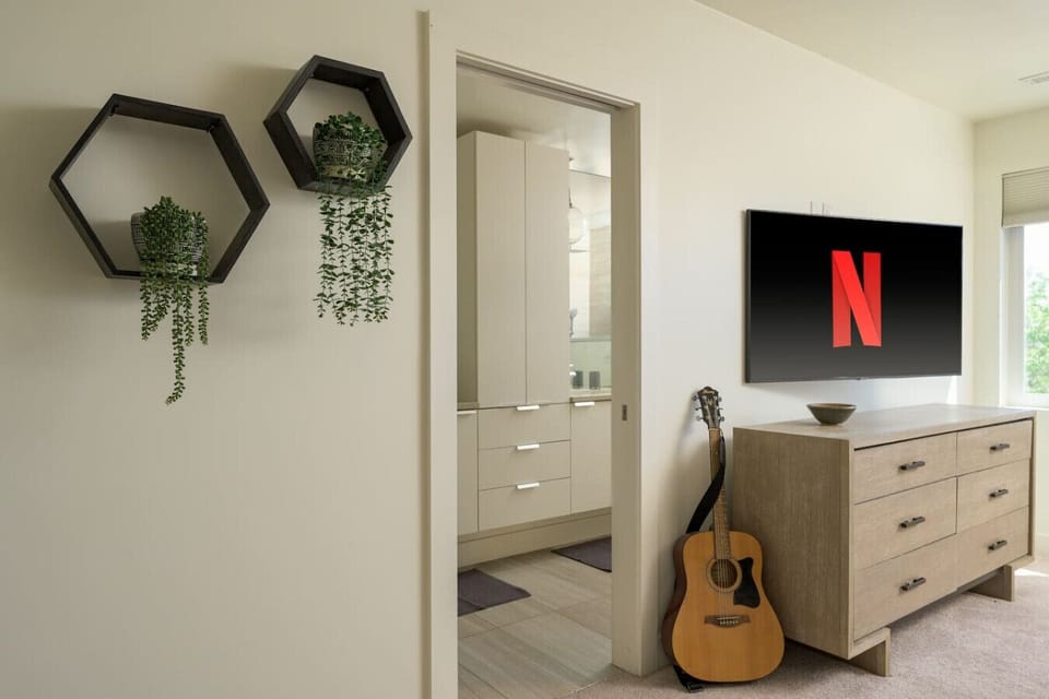 Primary bedroom with king bed, en suite bathroom, workspace and smart TV