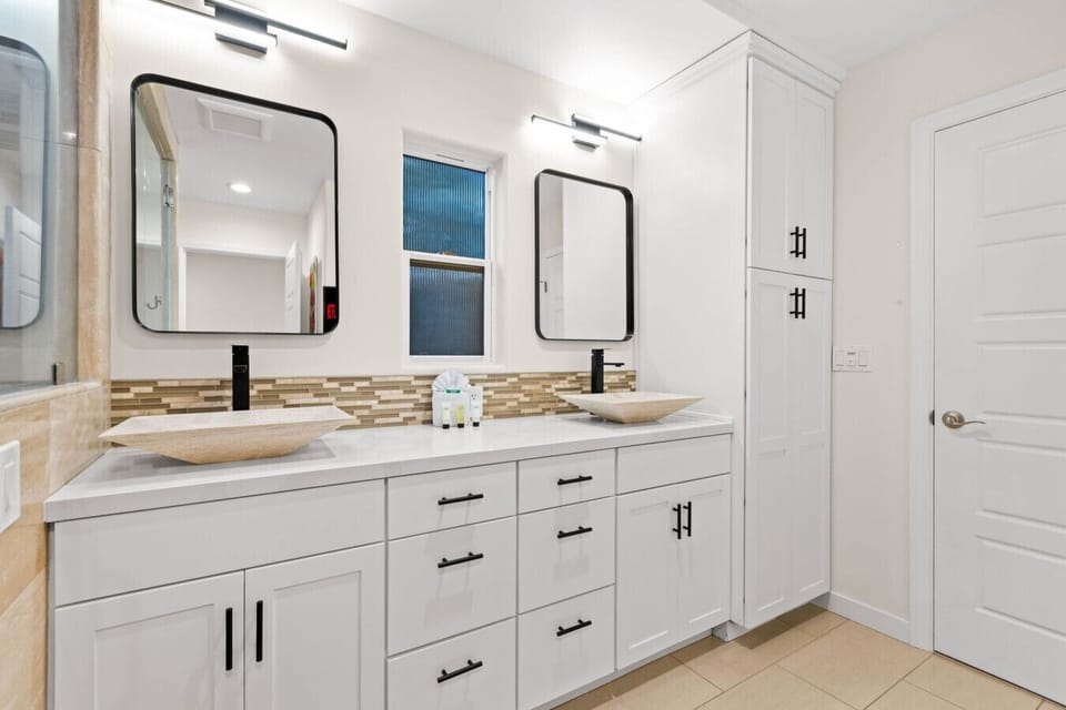 Bright and modern bathroom with dual sinks and ample space.