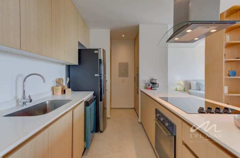 Sleek galley kitchen w/ modern cabinets, counter space & built-in appliances
