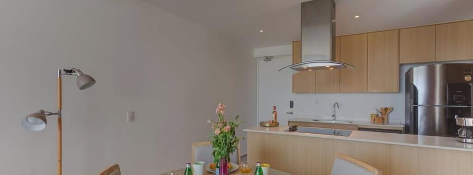 Dining table set for a meal beside the open kitchen, great for relaxed gatherings