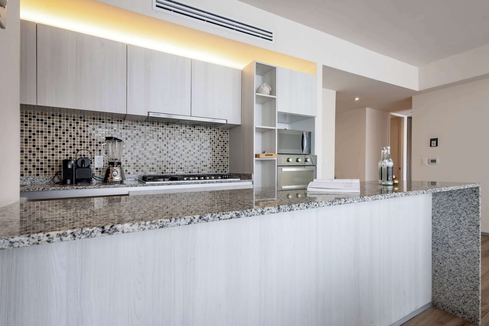 Sleek kitchen w/ modern cabinetry & long counters offering plenty of space to cook