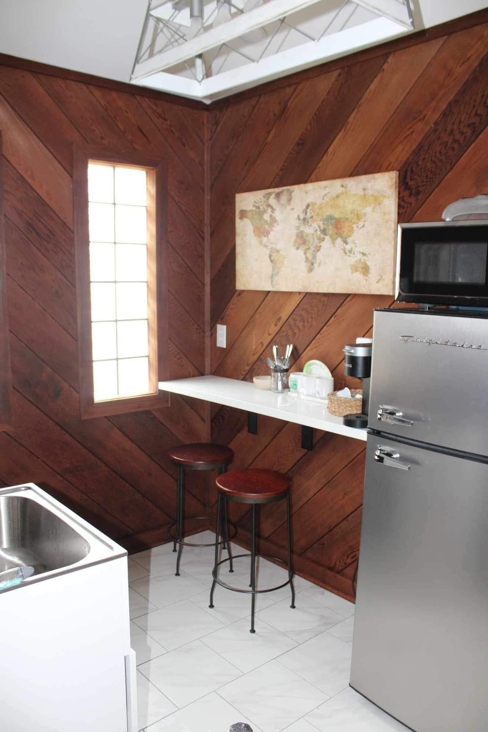 Guesthouse kitchenette sink, wine glasses, coffee, keurig & frig. Travelers Map.