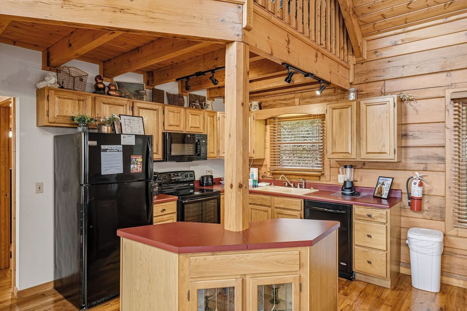 Your fully-equipped kitchen features warm wood cabinets, modern appliances, and a convenient island for preparing meals together.