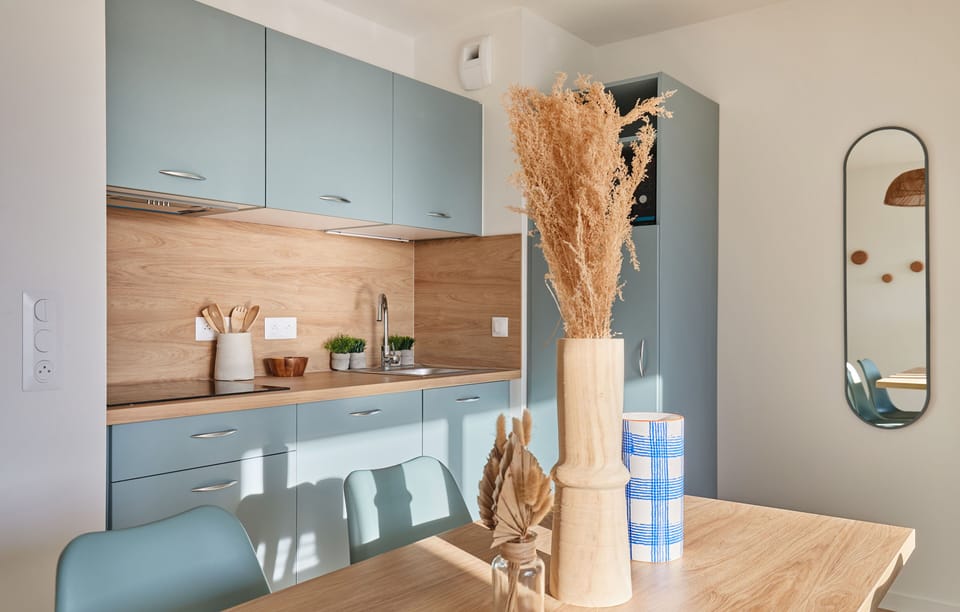 This contemporary kitchenette seamlessly integrates with the dining area, providing a functional space for meals in a homey setting, just minutes away from the beach.