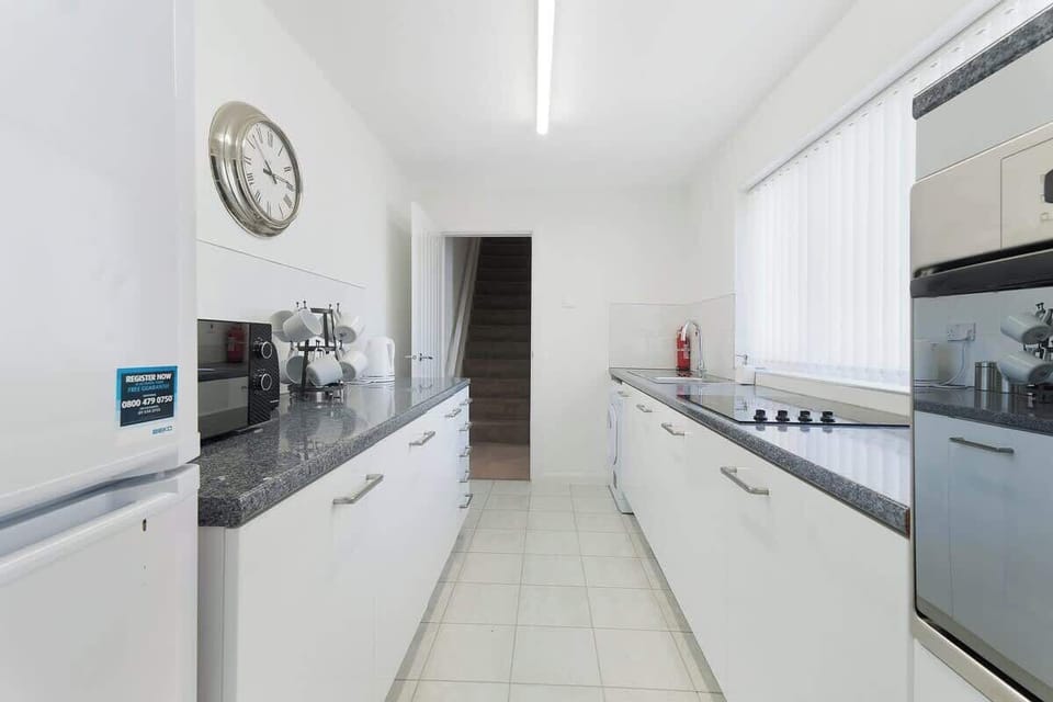 Kitchen equipped with all essentials, including an oven, fridge, and full cookware set.