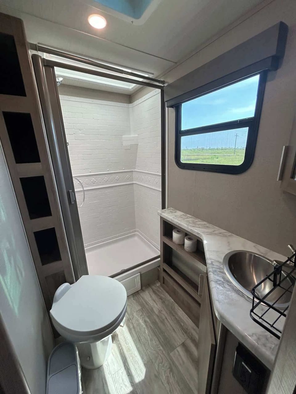 Bright, modern bathroom with walk-in shower and natural light. 