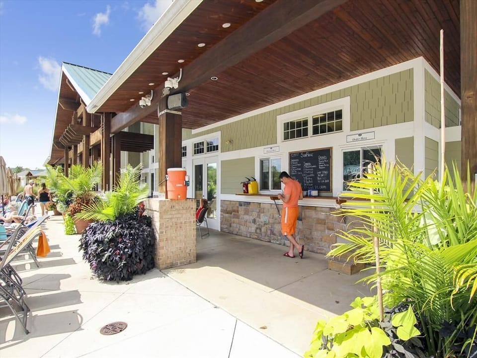 Savor refreshing snacks and drinks at the poolside bar, where guests can unwind in the lush tropical ambiance of the resort's clubhouse.