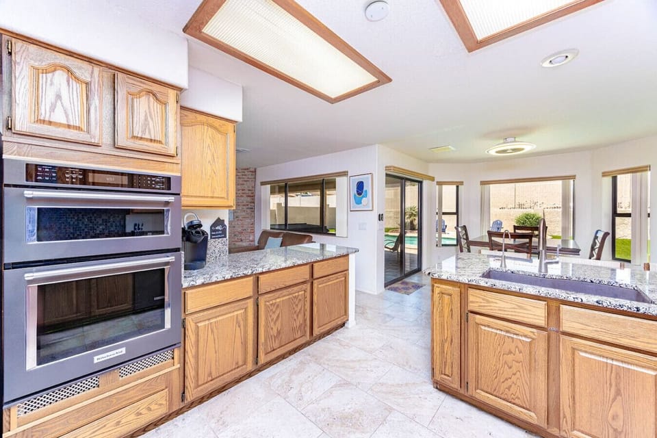 Cook, brew, and gather in this well-stocked kitchen featuring stainless steel appliances, a Keurig and drip coffee maker, and seating for three at the counter.