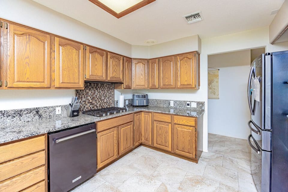 Modern kitchen with stainless steel appliances and  an air fryer for quick meals.
