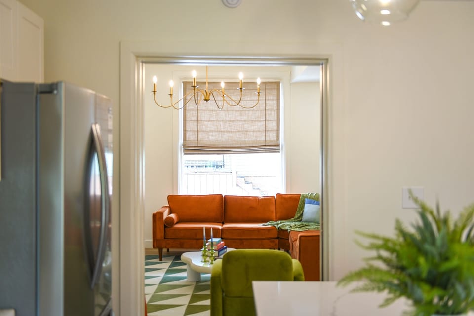 From bold lounging to vibrant cooking—our living room opens seamlessly into the colorful, modern kitchen