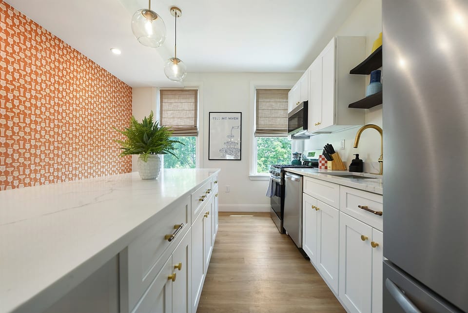 Sleek meets striking—our newly renovated kitchen blends modern design with bold pops of orange and blue for a space that cooks as good as it looks