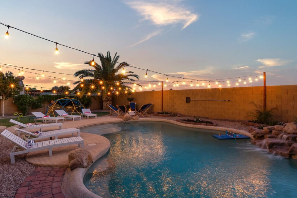 Your private desert paradise — crystal pool, waterfall, string lights, and total serenity.