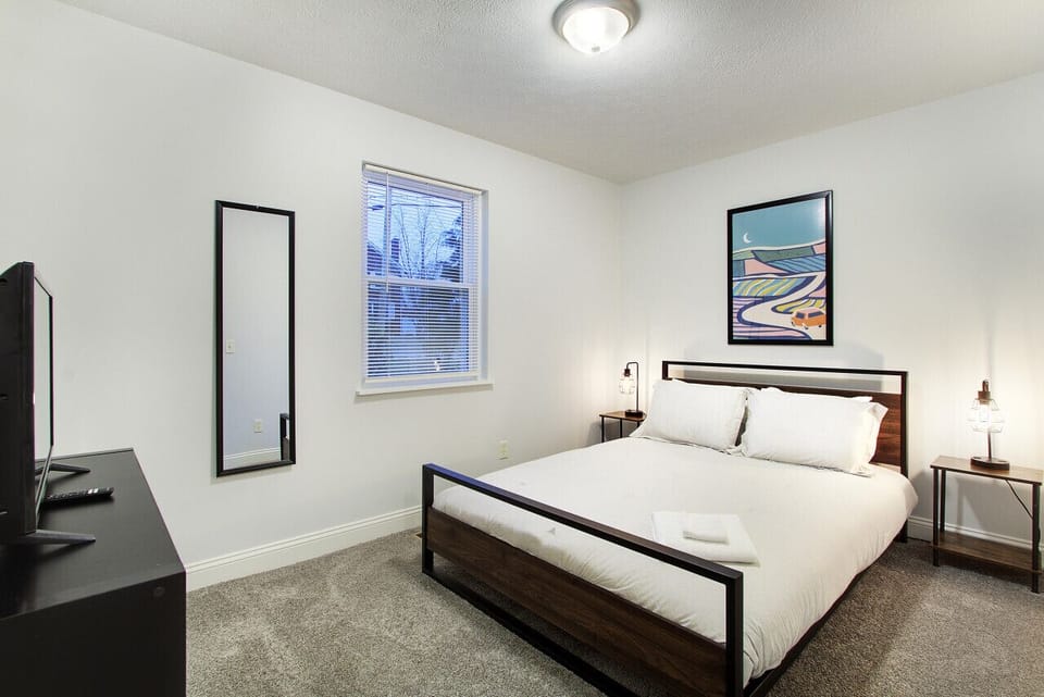 Queen bedroom with fresh linens and plenty of natural light