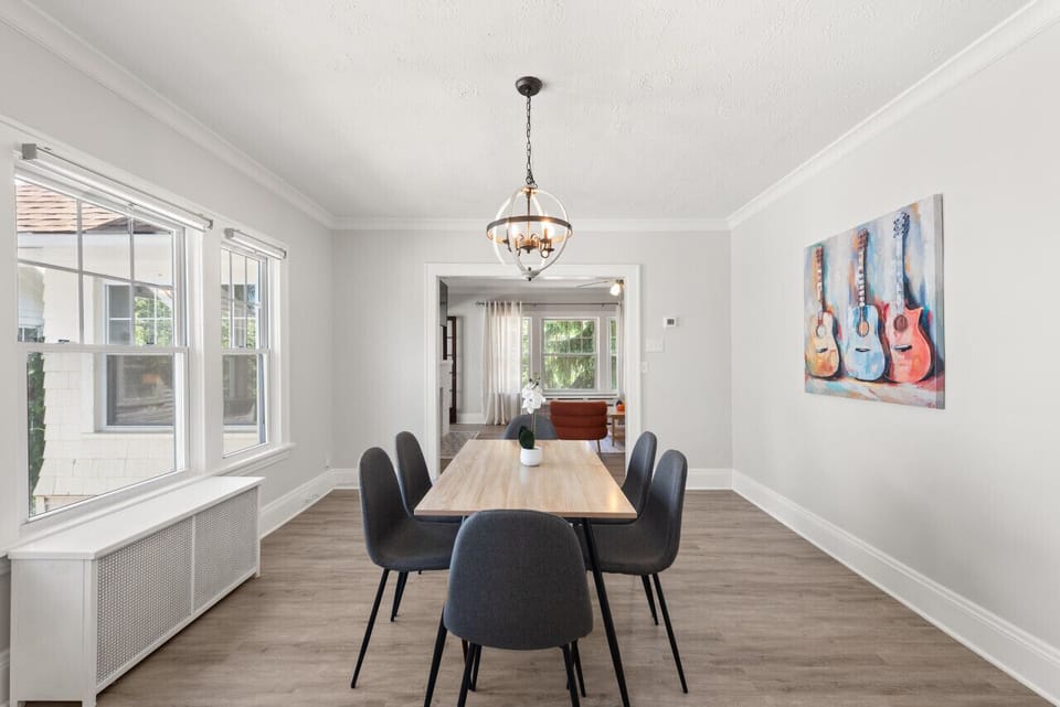 Bright dining room with large windows, comfortable seating, and seamless access to the living room and kitchen.