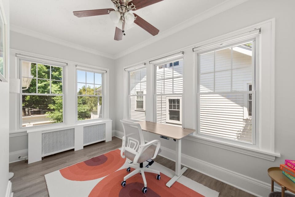Dedicated workspace with a desk, ergonomic chair, and abundant natural light for remote work or studying.