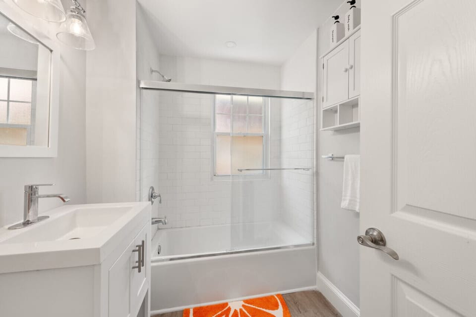 Modern full bathroom with a tub and shower combination, fresh towels, complimentary toiletries, and everything you need for a comfortable stay.
