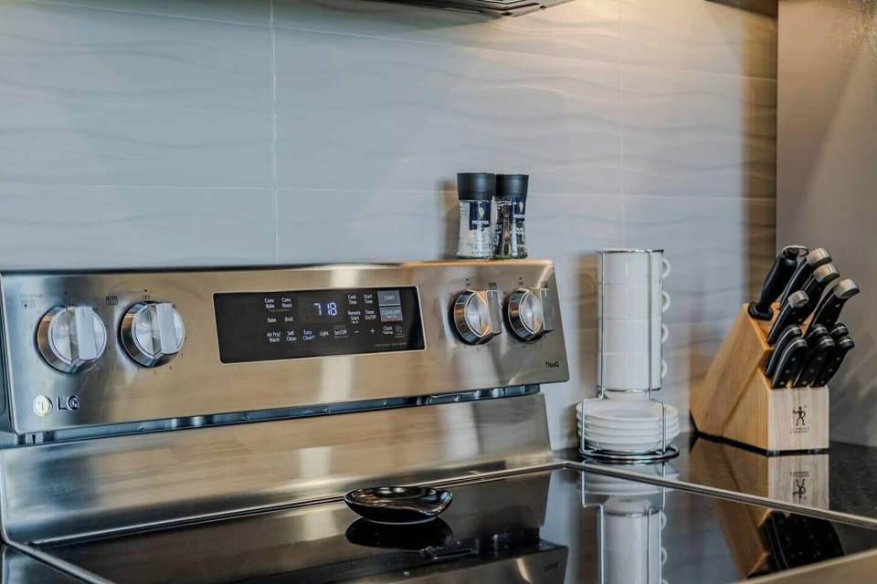 Modern cooktop and oven with fully stocked kitchen essentials for easy meal preparation.
